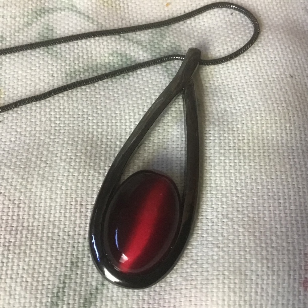 Pendant necklace with a red stone like a tiger eye